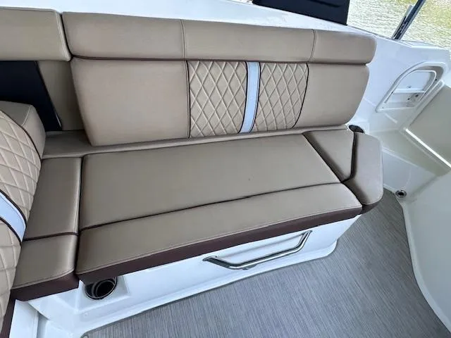 Slide: The Image of 2016 Sea Ray 270 Sundeck interior with beige cushioned seating and quilted design. - 21