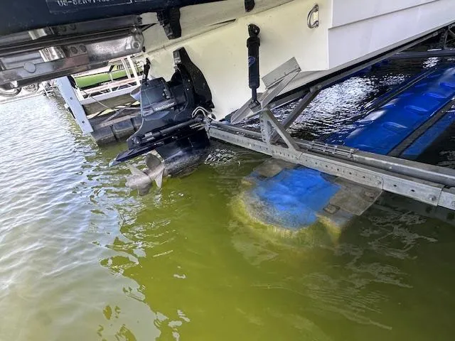 Slide: The Image of 2016 Sea Ray 270 Sundeck boat on lift, showing propeller and hull in water. - 35