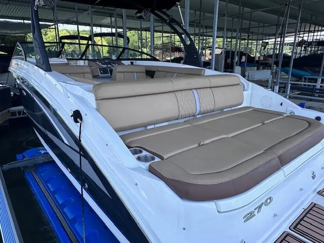Slide: The Image of 2016 Sea Ray 270 Sundeck boat with tan seating, docked under a covered marina. - 6