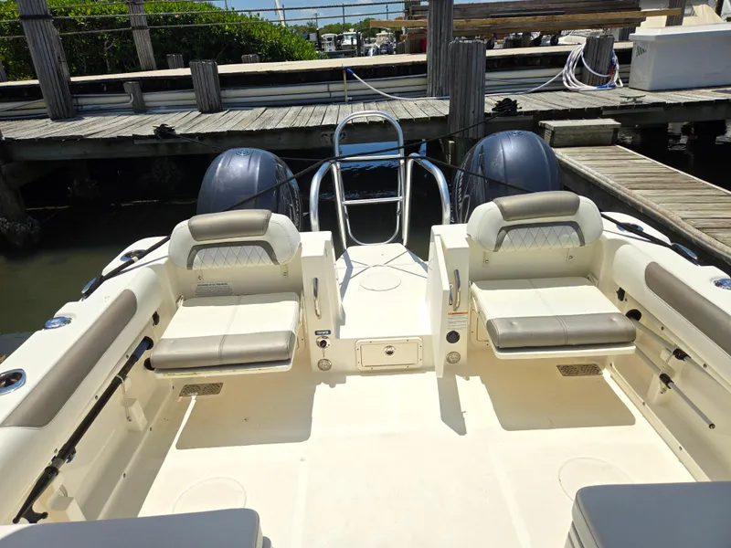 Slide: The Image of 2021 World Cat 255C boat interior with dual engines and seating at dock. - 10