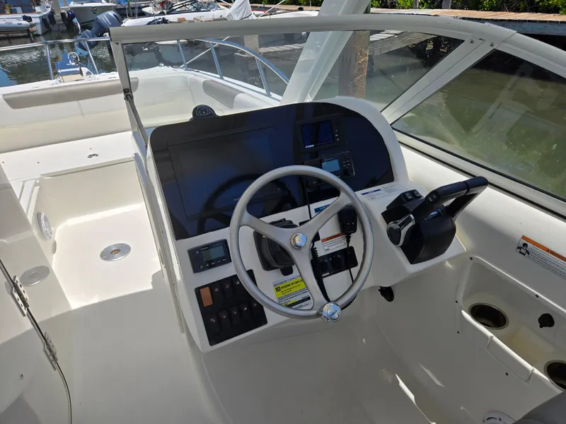 Slide: The Image of 2021 World Cat 255C boat helm with steering wheel and control panel. - 14