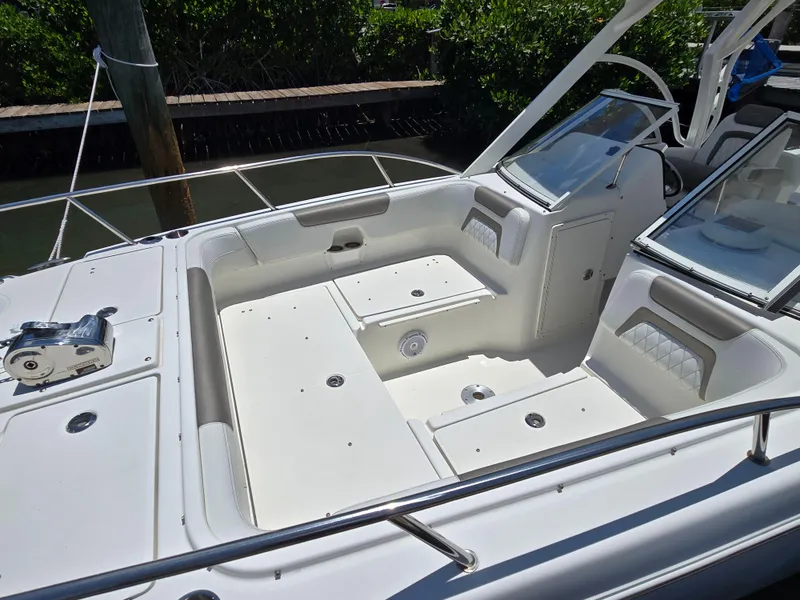 Slide: The Image of 2021 World Cat 255C boat interior with white seating and storage compartments. - 2