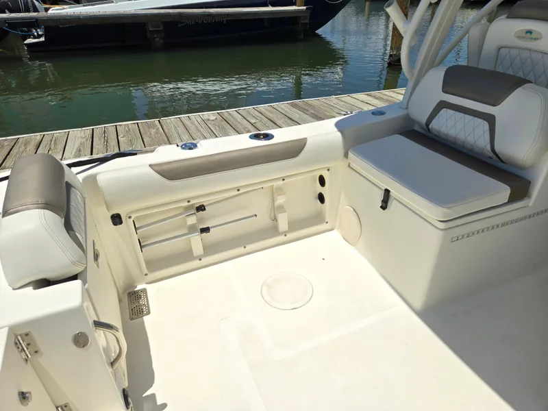 Slide: The Image of 2021 World Cat 255C boat interior with seating and storage, docked by the water. - 6