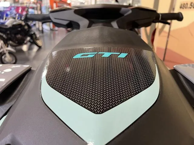 Slide: The Image of 2025 Sea-Doo Waverunner GTI, close-up of sleek design and logo in showroom. - 10