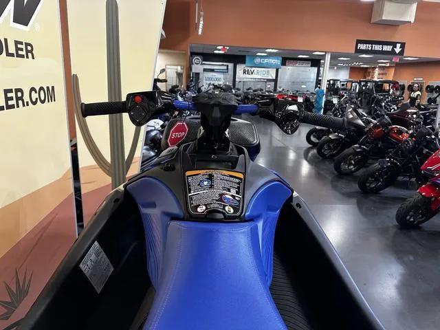 Slide: The Image of 2025 Sea-Doo Spark Trixx Waverunner, blue seat, showroom display, handlebars, and controls visible. - 6