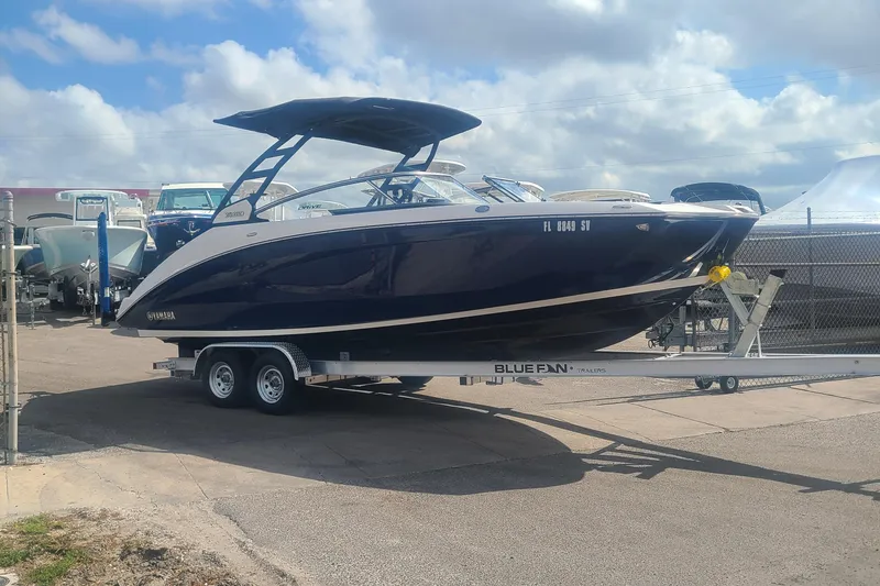 Slide: The Image of 2021 Yamaha Boats 252SE on trailer under cloudy sky. - 1