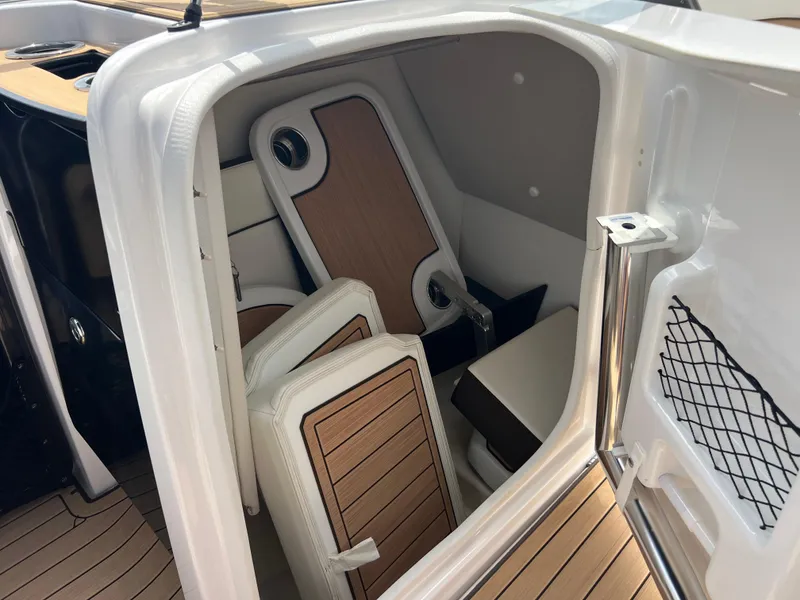 Slide: The Image of 2021 Yamaha Boats 252SE interior cabin with wood accents and seating. - 22
