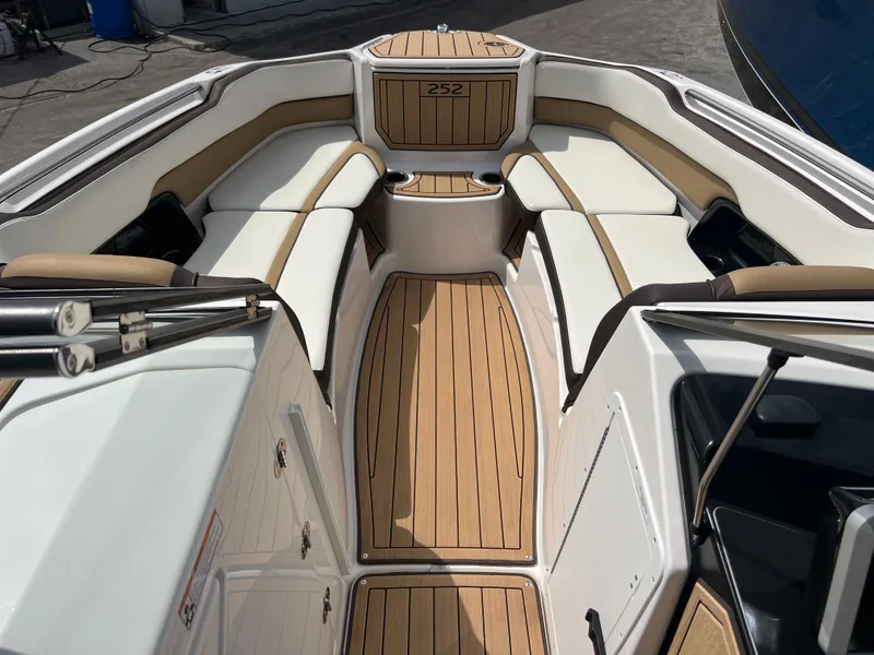 Slide: The Image of 2021 Yamaha Boats 252SE interior with sleek seating and wood-style flooring. - 23