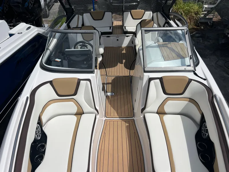 Slide: The Image of 2021 Yamaha Boats 252SE interior with tan and white seating, open cockpit, and sleek design. - 25