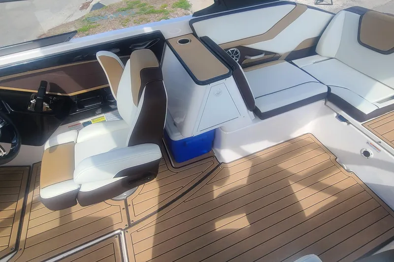 Slide: The Image of 2021 Yamaha Boats 252SE interior with white and brown seating, wood-style flooring. - 31