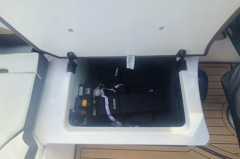 Slide: The Image of Open storage compartment in 2021 Yamaha Boats 252SE, showing life jackets and equipment. - 38