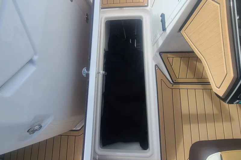 Slide: The Image of 2021 Yamaha Boats 252SE storage compartment with open lid, featuring teak-style flooring. - 39