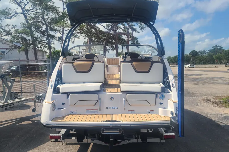 Slide: The Image of 2021 Yamaha Boats 252SE, rear view, docked, showcasing seating and deck design. - 6