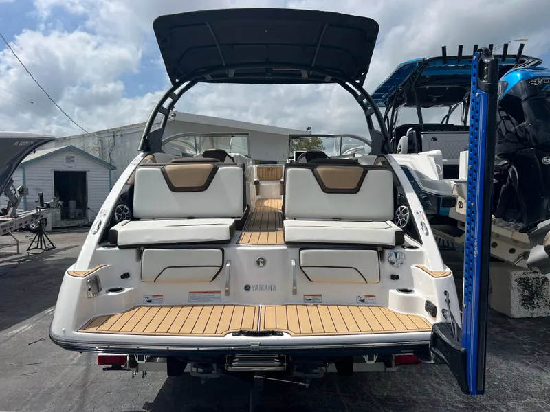 Slide: The Image of 2021 Yamaha Boats 252SE with sleek design and spacious seating, showcased outdoors. - 7