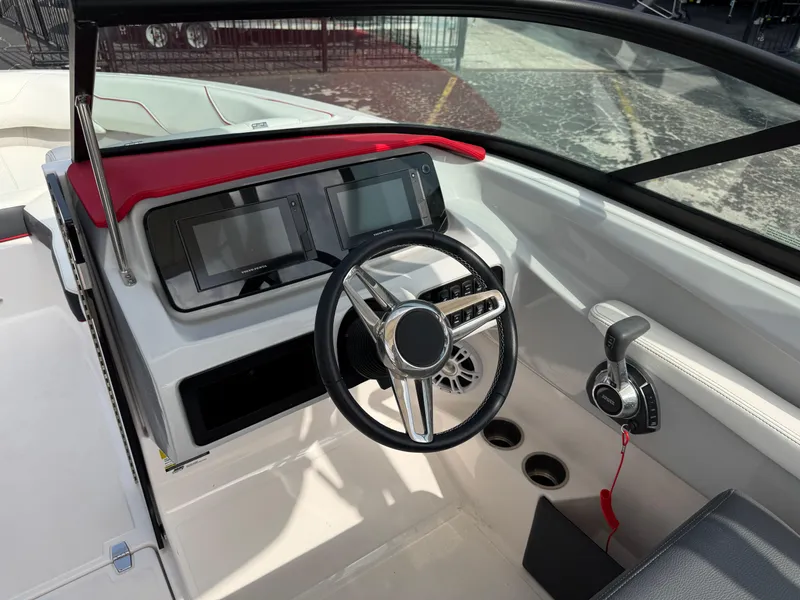 Slide: The Image of 2020 Regal LS2 Surf boat dashboard with steering wheel and dual displays. - 16