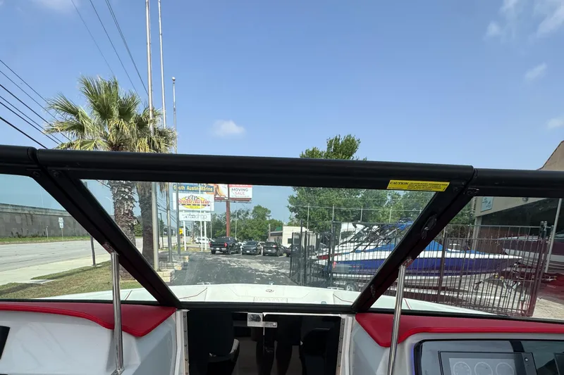 Slide: The Image of 2020 Regal LS2 Surf boat interior view with windshield, parked outdoors. - 20