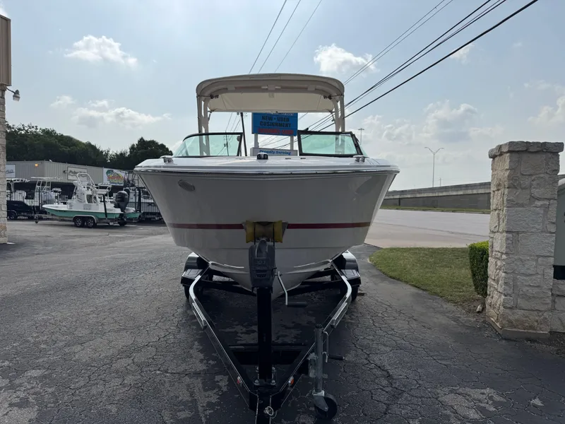 Slide: The Image of 2020 Regal LS2 Surf boat on trailer, parked outdoors under a clear sky. - 5
