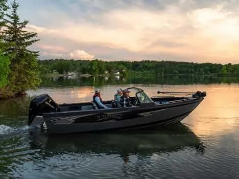 Slide: The Image of 2026 Lund 2075 Tyee boat cruising on a serene lake at sunset. - 0