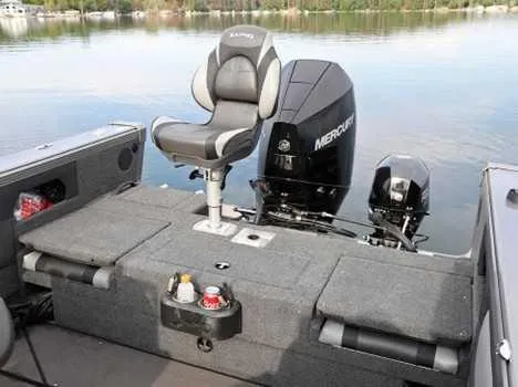 Slide: The Image of 2026 Lund 2075 Tyee boat interior with Mercury engine on a calm lake. - 12