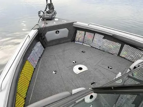 Slide: The Image of 2026 Lund 2075 Tyee boat interior with spacious deck and storage nets on calm water. - 6