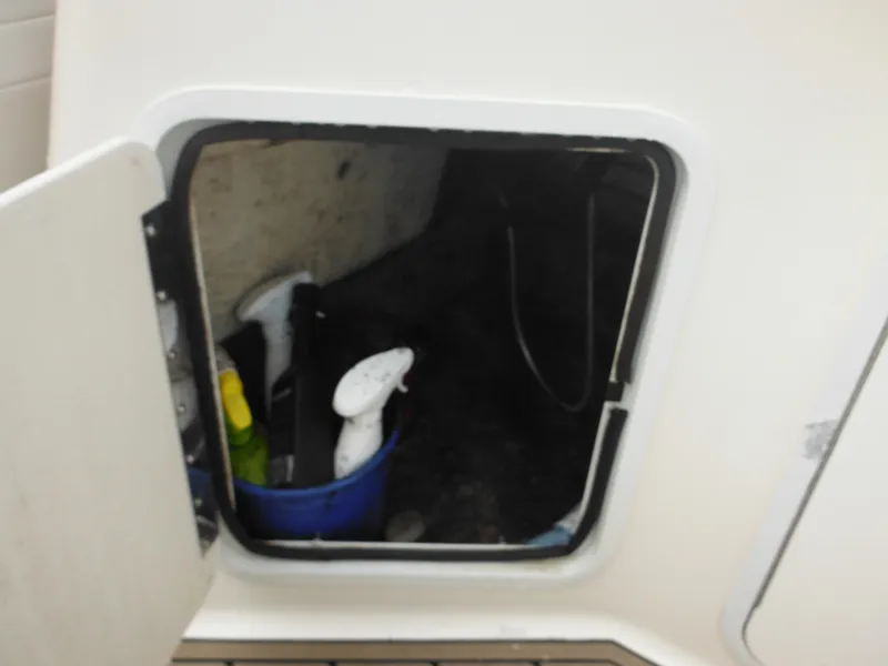 Slide: The Image of Open storage compartment on 2007 Hurricane SD 237 boat with cleaning supplies inside. - 28