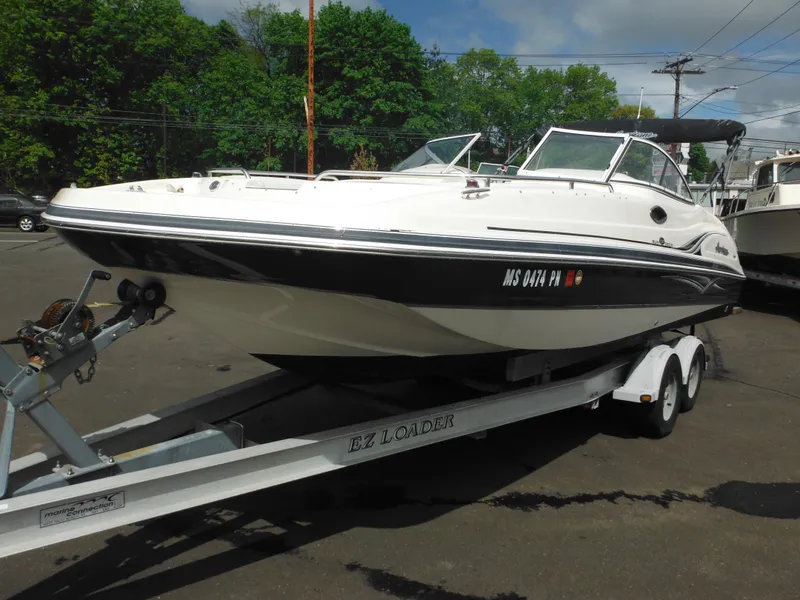Slide: The Image of 2007 Hurricane SD 237 boat on trailer, parked outdoors, with trees in the background. - 3