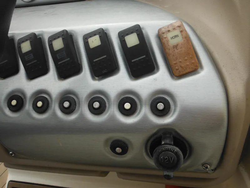 Slide: The Image of Control panel of a 2007 Hurricane SD 237 boat with switches and a 12V outlet. - 36
