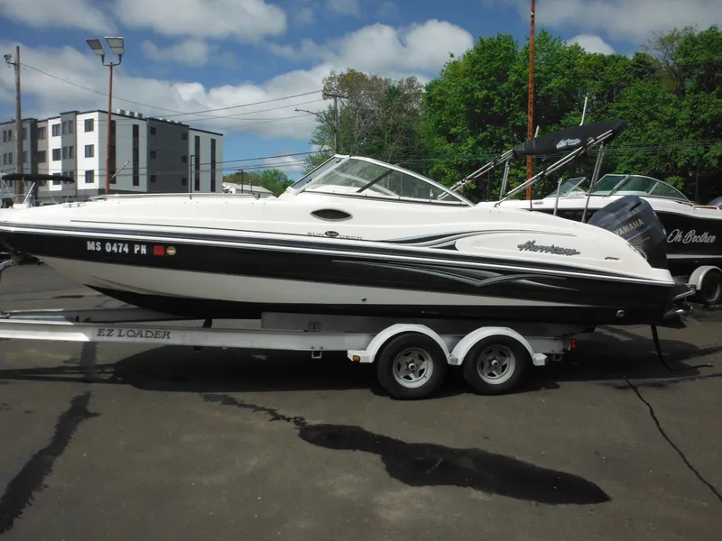 Slide: The Image of 2007 Hurricane SD 237 boat on trailer, parked outdoors, with trees and buildings in background. - 4