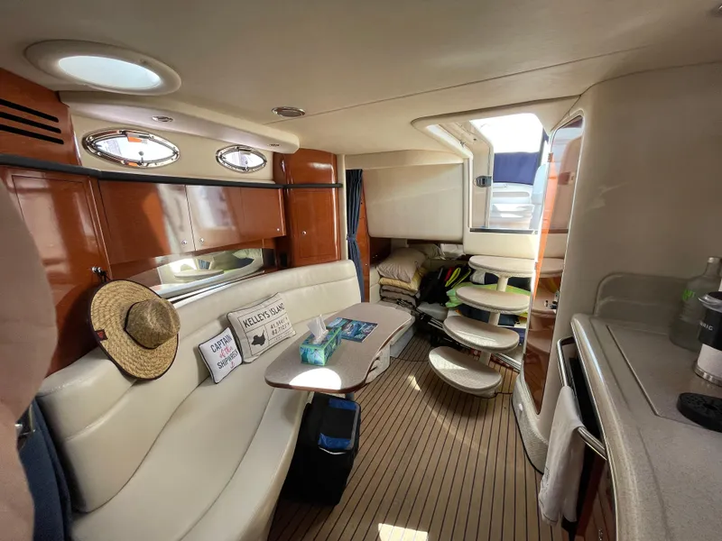 Slide: The Image of 2004 Sea Ray 320 Sundancer cabin interior with seating, table, and natural light. - 4
