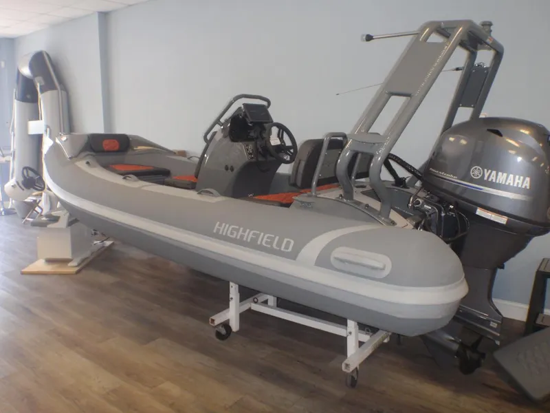 The Image of 2025 Highfield Sport 390 boat with Yamaha engine displayed indoors. - 0