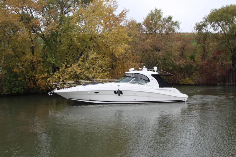 Slide: The Image of 2007 Sea Ray 44 Sundancer yacht cruising on a calm river with autumn trees. - 2