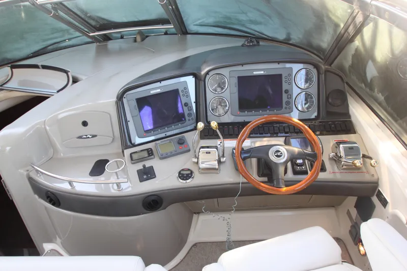Slide: The Image of 2007 Sea Ray 44 Sundancer helm with dual navigation screens and wooden steering wheel. - 23