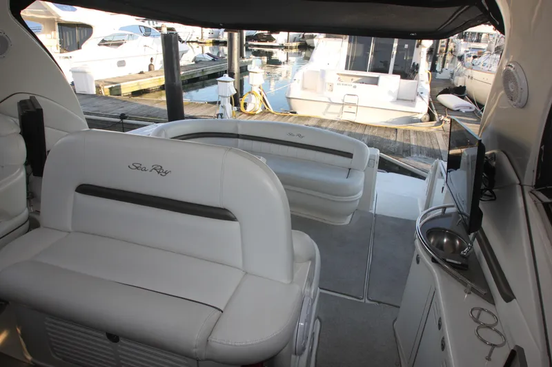 Slide: The Image of 2007 Sea Ray 44 Sundancer yacht interior with white seating and marina view. - 25