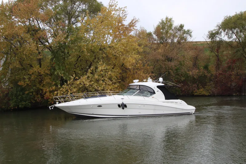 Slide: The Image of 2007 Sea Ray 44 Sundancer yacht cruising on a calm river with autumn trees in the background. - 3