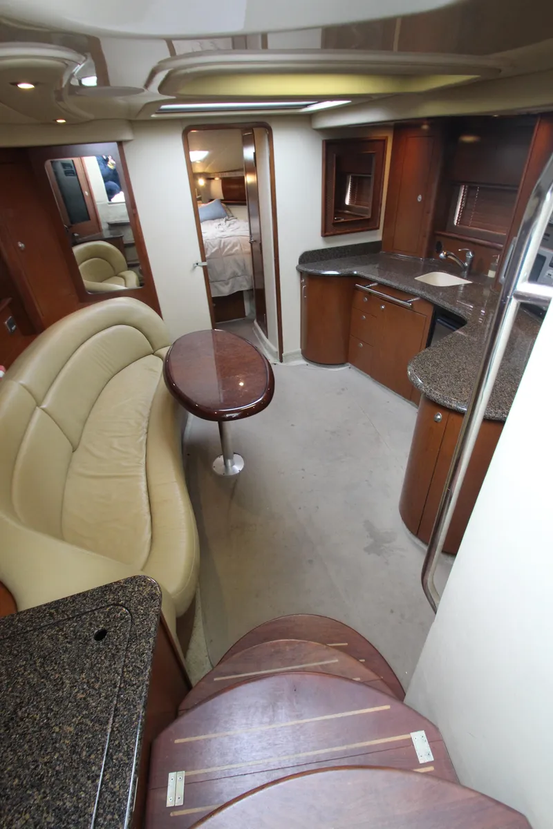 Slide: The Image of 2007 Sea Ray 44 Sundancer interior with modern kitchen, curved sofa, and elegant wood finishes. - 31