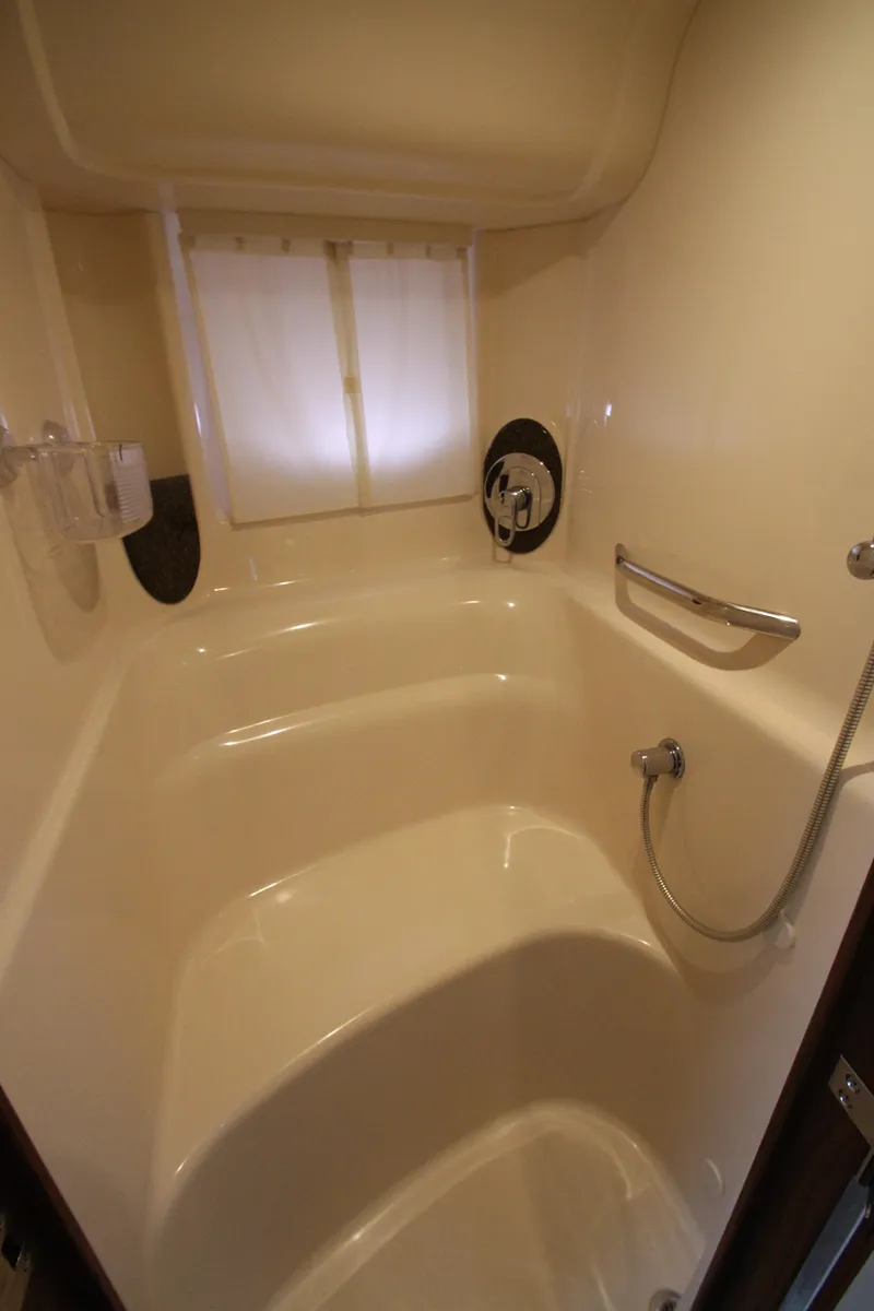 Slide: The Image of 2007 Sea Ray 44 Sundancer bathroom with shower, white interior, and window. - 40