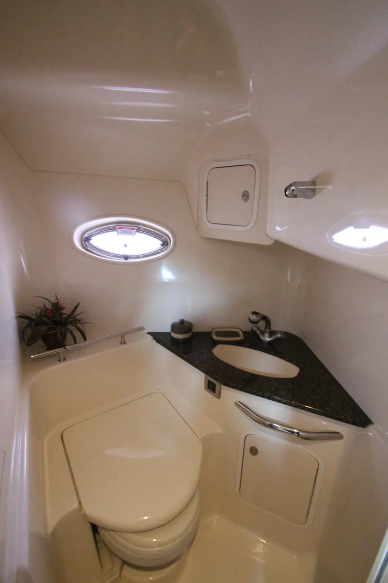 Slide: The Image of 2007 Sea Ray 44 Sundancer bathroom with compact design, porthole, and sleek fixtures. - 48