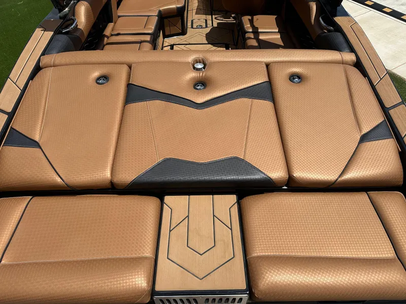 Slide: The Image of 2023 Supreme S220 boat interior with luxurious tan and black upholstery design. - 10