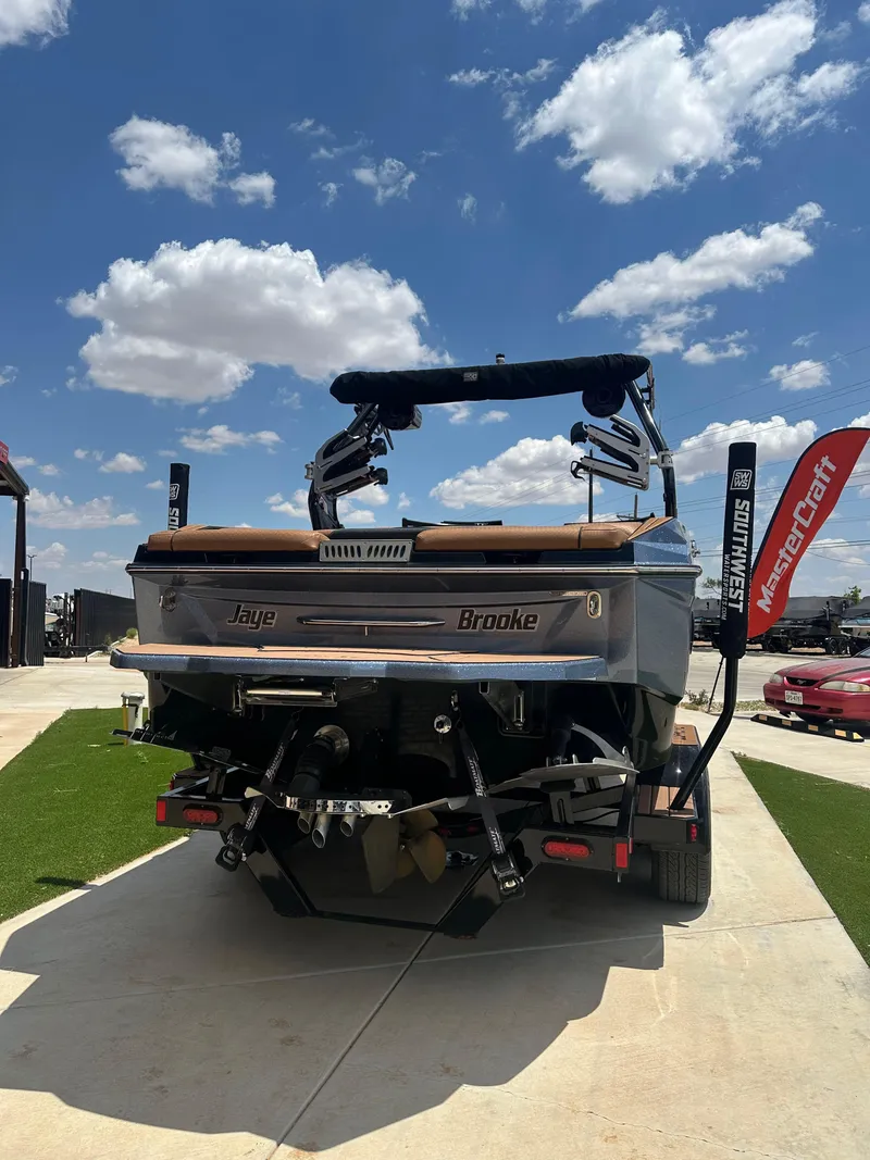 Slide: The Image of 2023 Supreme S220 boat on display under a bright blue sky. - 14