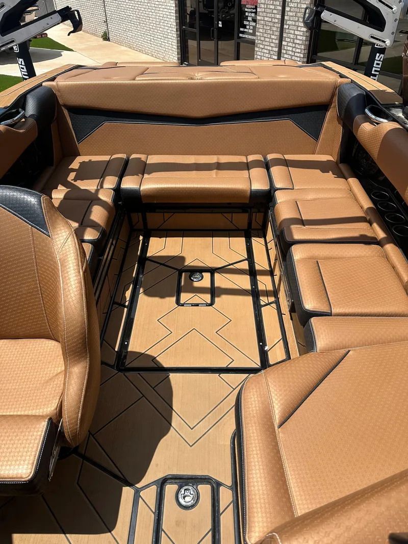 Slide: The Image of 2023 Supreme S220 boat interior with luxurious brown seating and modern design. - 8