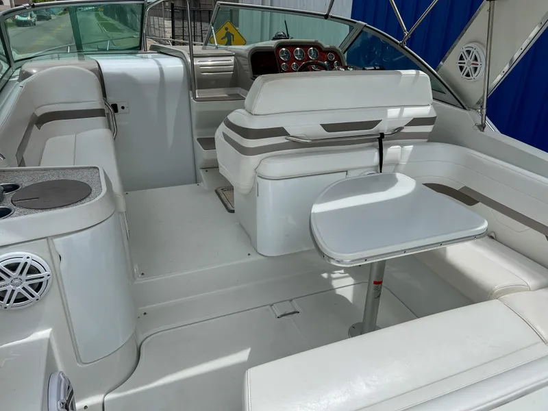 Slide: The Image of 2004 Formula 27 PC boat interior with white seating and table, featuring a sleek dashboard. - 12