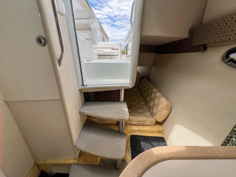 Slide: The Image of Interior of a 2004 Formula 27 PC boat, featuring stairs and a cozy seating area. - 26