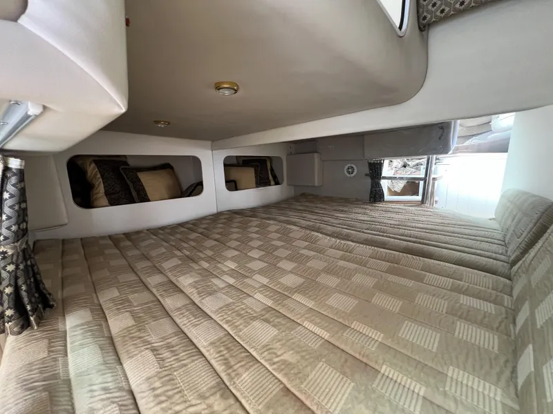 Slide: The Image of 2004 Formula 27 PC cabin interior with beige bedding and decorative pillows. - 27