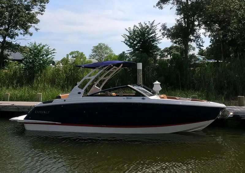 The Image of 2026 Cobalt R6 boat docked by lush greenery and calm water. - 0