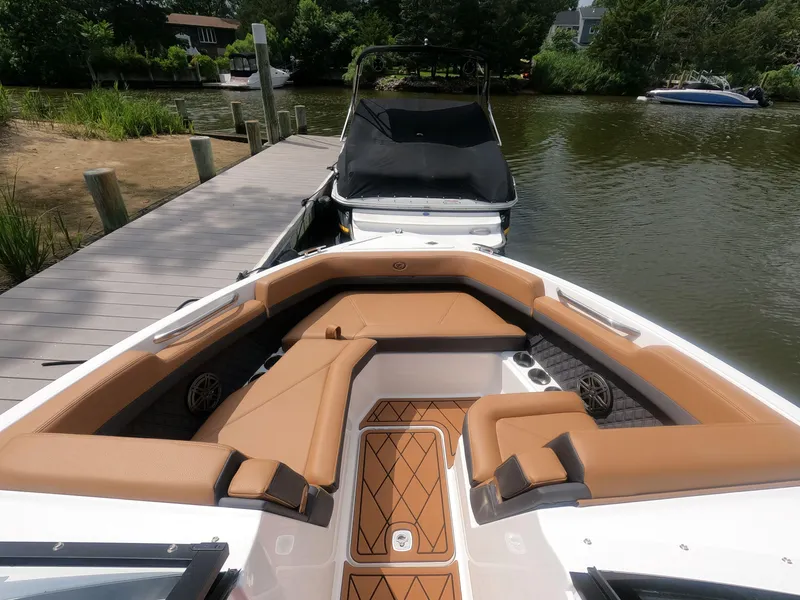 Slide: The Image of 2026 Cobalt R6 boat with tan seating docked by a wooden pier. - 18