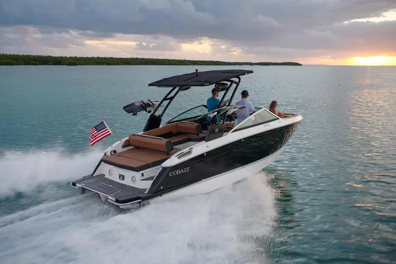 Slide: The Image of 2026 Cobalt R6 boat cruising on water at sunset with passengers onboard. - 22