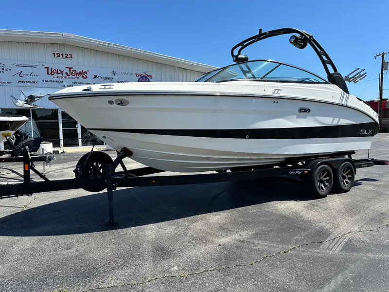 The Image of 2023 Sea Ray 260 SLX boat on trailer, parked outside a building. - 0