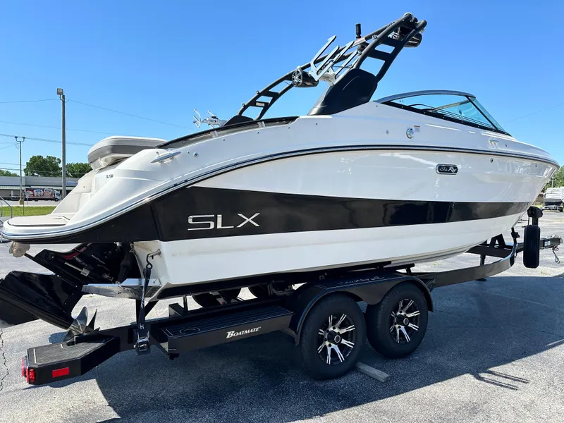 Slide: The Image of 2023 Sea Ray 260 SLX boat on trailer under clear blue sky. - 5
