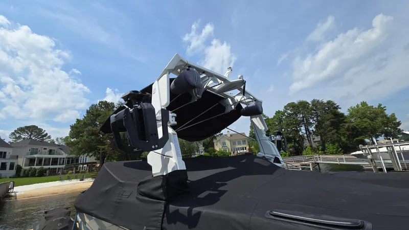 Slide: The Image of 2022 Correct Craft Super Air Nautique G23 boat with covered deck, docked by waterfront homes. - 11