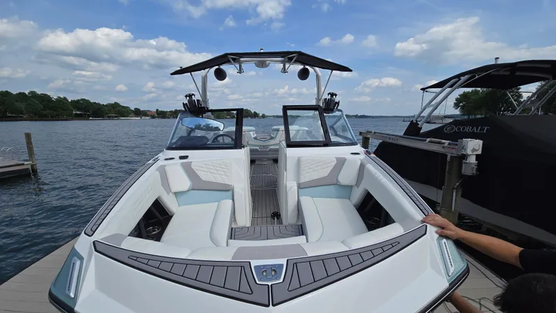 Slide: The Image of 2022 Correct Craft Super Air Nautique G23 boat docked on a sunny day. - 13